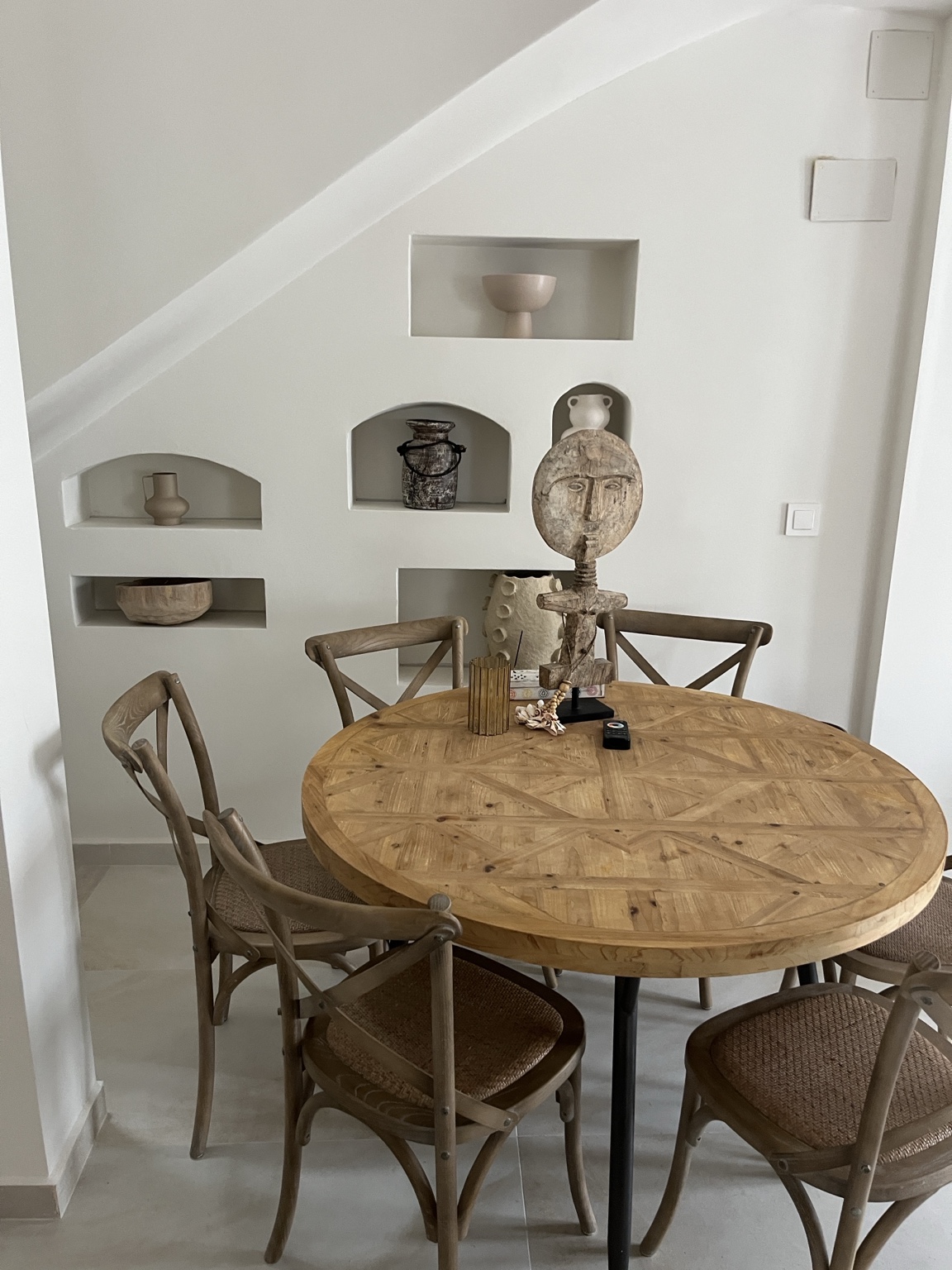 Comedor con mesa de madera y hornacinas de obra bajo la escalera